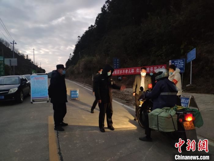 图为：1月29日，零下5℃，陈荣侯和工作人员在村口卡口处值班。　陈小琼 摄