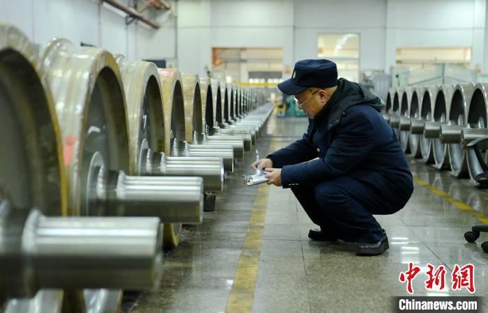生产车间里工人师傅正在核对每一根车轴编号。　刘忠俊 摄