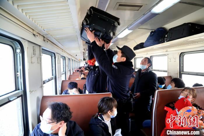 学警李德健和父亲李章龙主动帮助乘车的困难旅客放置行李箱。 郝黎俊 摄 学警李德健和父亲李章龙主动帮助乘车的困难旅客放置行李箱。 郝黎俊 摄